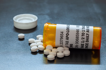 Prescription bottle with backlit Lorezapam tablets. Lorezapam is a generic prescription anti-anxiety medication. A concept for mental health.