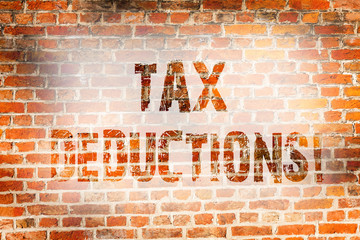 Conceptual hand writing showing Tax Deductions. Concept meaning Reduction on taxes Investment Savings Money Returns Brick Wall art like Graffiti motivational written on wall