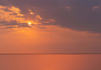 Bright sunset with  yellow sun under the sea, Sky background on sunset. Nature composition.