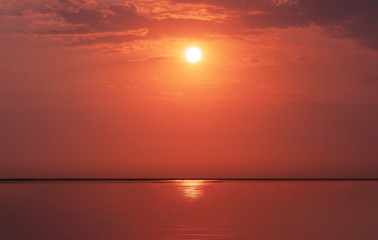 Bright sunset with  yellow sun under the sea, Sky background on sunset. Nature composition.