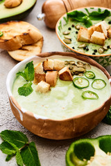 bowls of delicious green vegetable creamy soup with crispy croutons