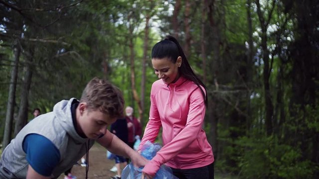 Group of fit people picking up litter in nature, a plogging concept.