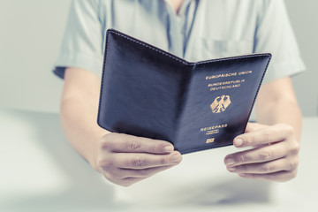 Immigration and passport control at the airport. woman border control officer with Deutsch passport of German citizen. Concept