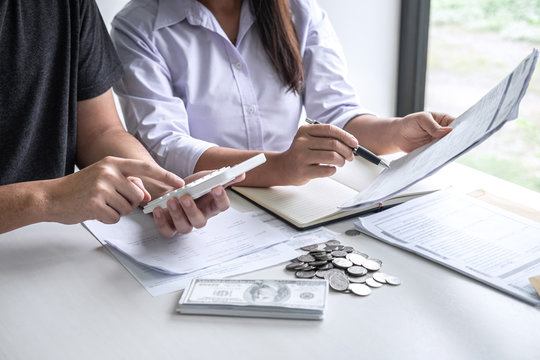 Images of Husband and wife using calculator to calculating expenditure receipt bills of various activity cost and expenses in home office and written make report to plan of spent in future