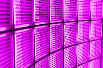 Wall of modern glass building of business center. Skyscrapers, metropolis, building structures and materials. Neon pink color.