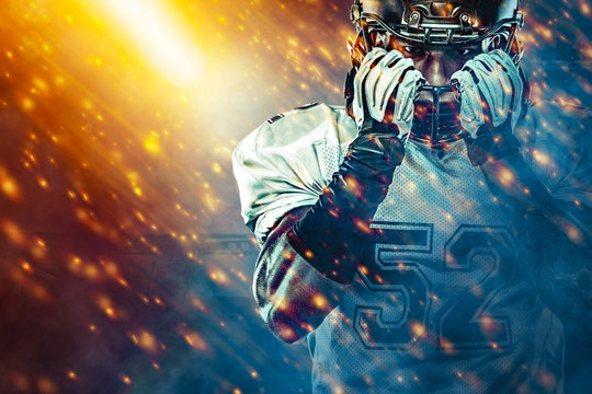 American football sportsman player on stadium running in action. Sport wallpaper with copyspace. Team sports.