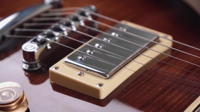 Electric guitar strings and body close up. Classical style rock music instrument