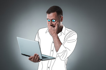 Handsome young man with a cartoon eyes and shirt is holding a laptop, looking at it and acting like he is shocked.