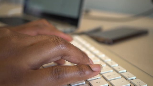 Closeup African American woman typing a blog article from home