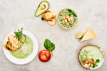 top view of delicious creamy green vegetable soup served with greenery and croutons