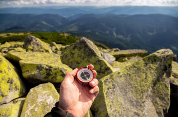 Compass in the hands in the Carpathian mountains. Traveling in the mountains. © Sergii