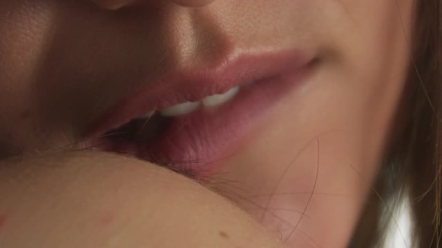 Young Caucasian female biting on her lip, close-up footage