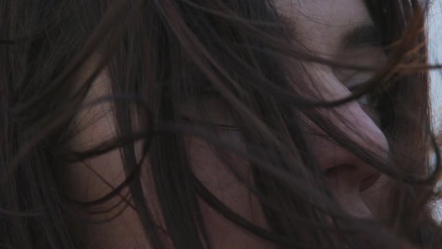 Close-up of a young female in her 20s standing outside in the wind