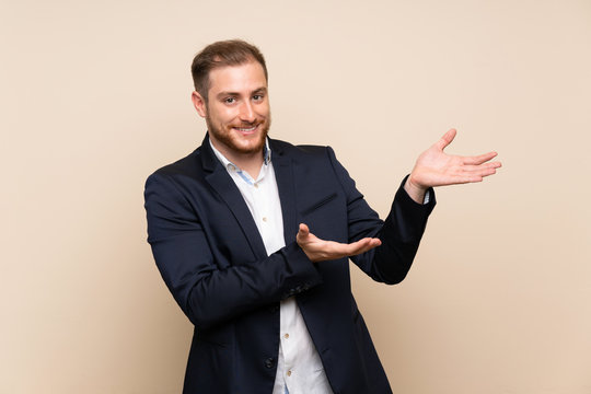 Blonde man over isolated background extending hands to the side for inviting to come