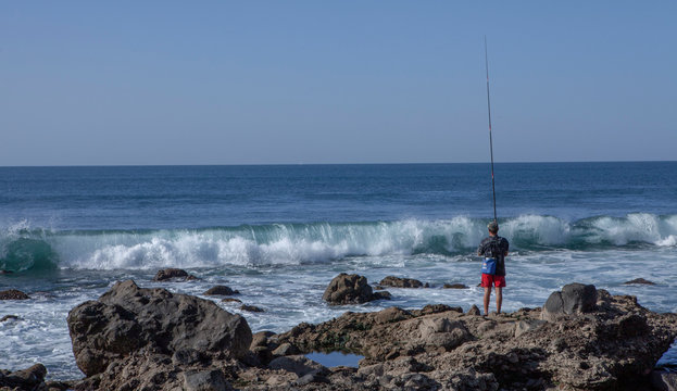 Gran Canaria Spain Maspalomas beach ocean rocks. Man fishing. Wave. Breakers.