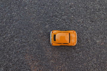 Top view shot of orange toy car on clean background.