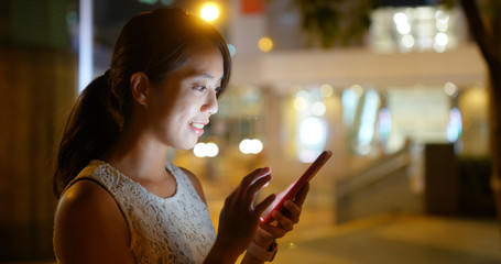 Woman use of mobile phone online at night