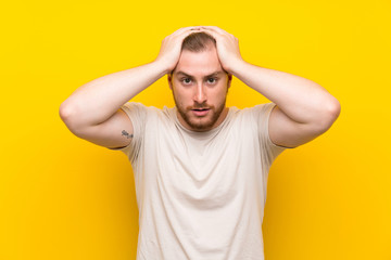 Handsome man over yellow background with surprise facial expression