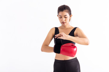 Fit Asian woman putting on red boxing gloves before boxing workout on white background. Young...