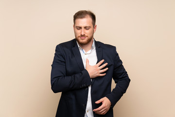 Blonde man over isolated background having a pain in the heart