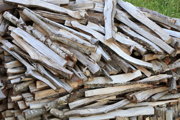 Firewood dry firewood in a pile for furnace kindling. Rustic background of logs