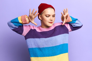 funny talented girl with raised arms enjoying dancing. close up portrait,isolated blue background