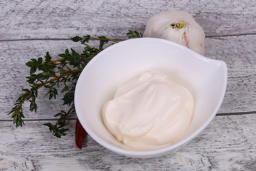 Mayonnaise sauce in the white bowl served thyme and garlic