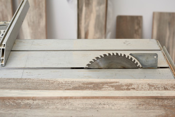 Machine of circular saw to cut wood. The process of installing laminate wooden on the floor. Home construction.
