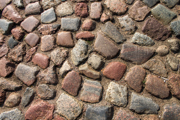 Cobblestone road. Multicolored cobblestone texture.