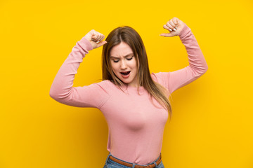 Teenager girl over isolated yellow background celebrating a victory