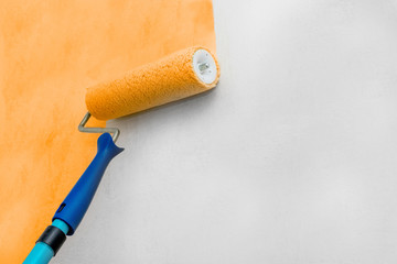 Paint the walls with a roller. Painting works. Orange paint, white wall. Repairs.