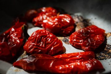 Baked red sweet peppers in halves. On white paper