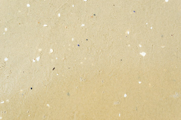 wet yellow sand on the sea beach as background