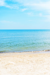 view to sea and sand beach under blue sky with clouds