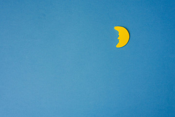 Yellow Crescent moon against blue night sky. Application paper on the right. Copy space