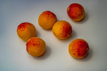 Ripe apricots on white background and in plate