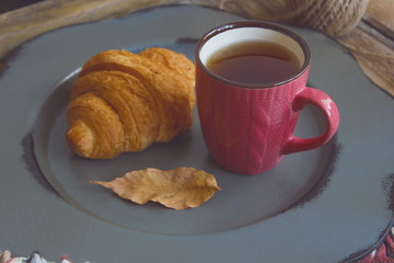 Autumn mood french breakfast composition cup of tea and croissants