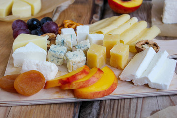 Rustic cheese platter with different cheese and grapes