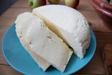 Slices of cheese, medium hard cheese, homemade or Swiss cheese and hard cheese on a wooden surface. copyspace
