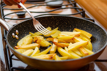 Frying of golden fried potatoes chips on olive oil