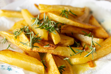 Golden fried potatoes chips  with fresh aromatic rosemary herb