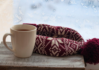 cup of tea by the snowy window, winter or christmas concept