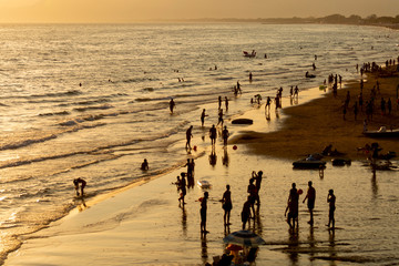 Fototapeta na wymiar Silhouettes of people on sandy beach on sunset in Sperlonga, Lazio, italy, summer vacation