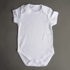 Flat Put a white bodysuit for a child on a gray background, isolate. Layout for design and placement of logos, advertising