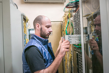  The man replaces the server in the rack. The engineer removes computer equipment from the server...