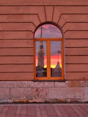 Reflection of Peter and Paul fortress in the window at sunset