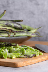 Heap of green beans on a rustic wooden table top view. Cutting board with green beans