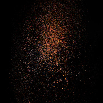 Cocoa powder sifting isolated on black background. Chocolate dust on black background