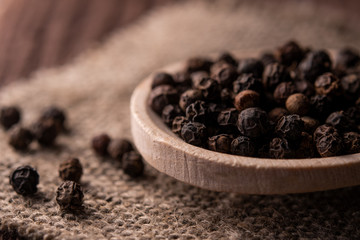 spoon with black pepper on jute fabric