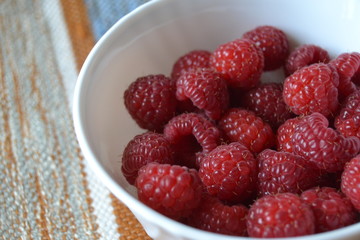 raspberries in the small white bowl. fresh organic berries.